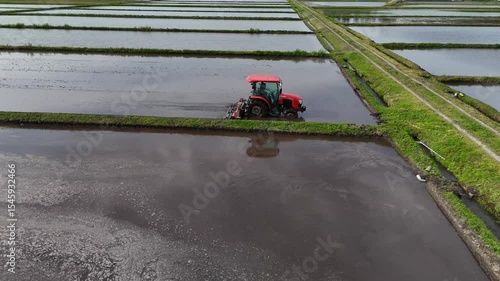 農地を耕しているトラクター　水田　田んぼ　米　稲　イメージ　農業　空撮	