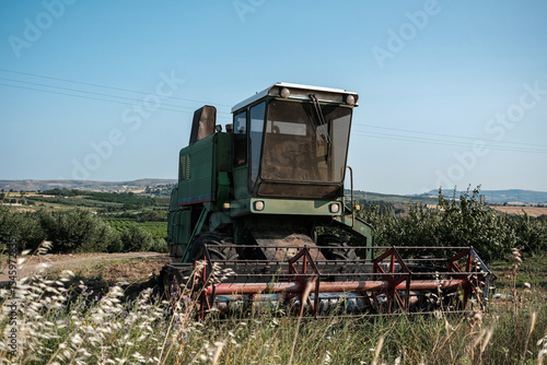 Green combine harvester standing on a field in day time