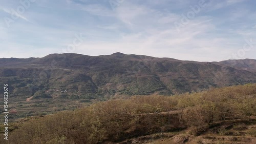 Aerial drone footage of Jerte Valley river, farmland and mountain landscape in Spain.