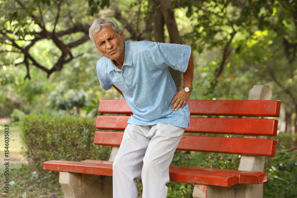 Fototapeta premium Indian Senior man suffering from back pain in the park.