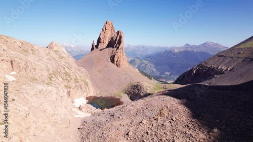 Solo hiker standing in awe before Agujas de Lavasar in the Pyrenees of Aragón, 4K aerial drone shot of rocky alpine terrain, dramatic solitude in the remote Chistau Valley, Spain
