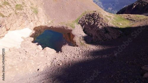Aerial 4K cinematic view of Agujas de Lavasar above Ibón de Lavasar, dramatic alpine terrain and rocky formations in the Chistau Valley, Cotiella region, Pyrenees of Aragón, northern Spain

