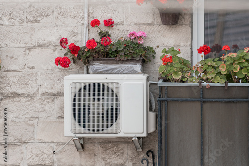 Exterior Air Conditioner Unit with Red Flowers on Stone Wall, Urban Cooling, Home Decor, Balcony Garden, Bright Colors, Realistic Photography