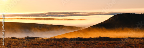 Panorama of a firey morning glow over low lying mist, cloud inversion, by Higger Tor, Hathersage, Peak District, UK