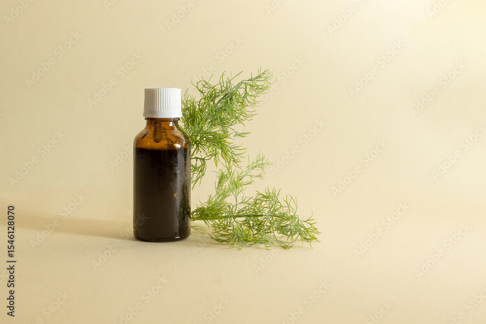 Bottle of essential oil with fresh dill on a beige background. Nature concept. Bottle of essential oil with fresh dill on a beige background. Nature concept.