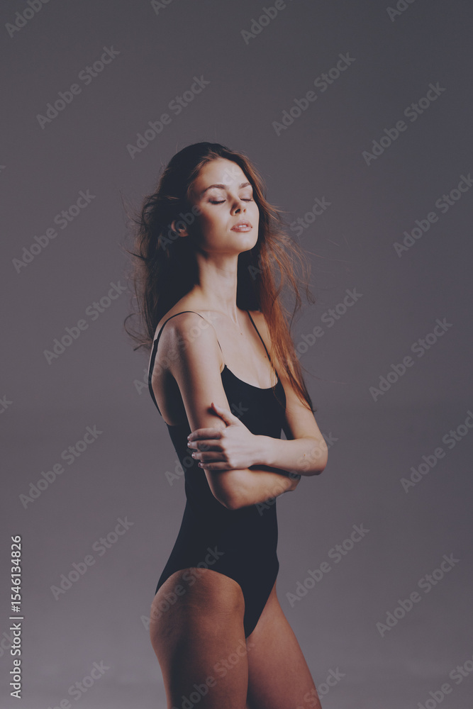 Fototapeta premium young woman in black bodysuit standing with closed eyes, natural makeup, soft lighting, relaxed pose, studio background, serene mood, calm expression