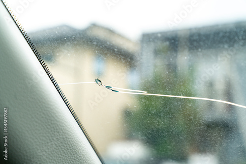 飛び石でヒビが入った車のフロントガラスの写真