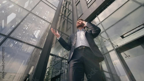 Wallpaper Mural Bottom view business man talking mobile phone call in city Caucasian businessman middle-aged male speaking with smartphone professional discuss working negotiation job near office building outside Torontodigital.ca