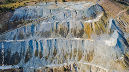 Aerial view of Tsar Asen Mine, Bulgaria – colorful terraced slopes of a former open-pit mine where non-ferrous metals, especially copper, were once extracted. Nature slowly reclaims the site.