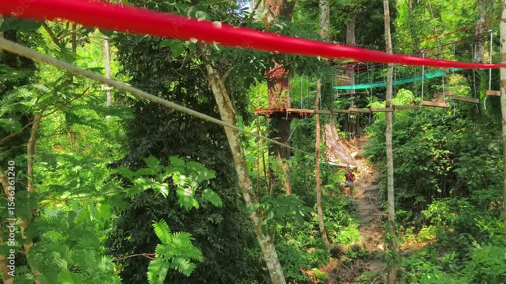 A man and a woman is walking across a challenging ropes course in the extreme park A man and a woman is walking across a challenging ropes course in the extreme park