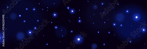 Blue glowing particles on dark background with soft bokeh light effect and dreamy cosmic atmosphere