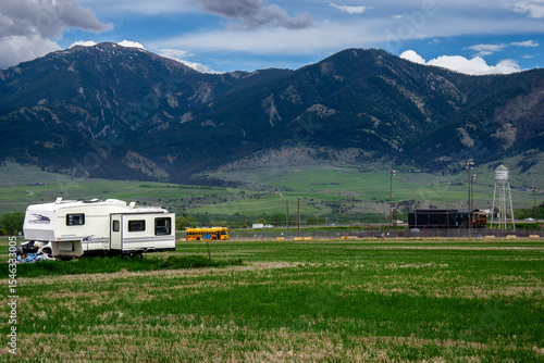 Green meadow with trailer and yellow school bus in Bozeman, Montana