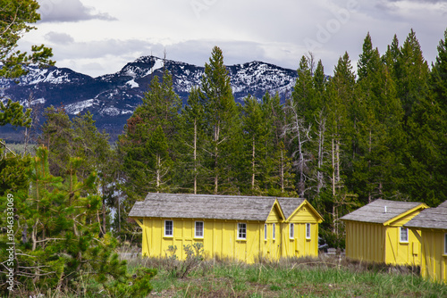 Yellow tourist cabins in Yellowstone mountains with cloudy sky