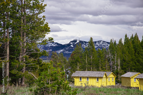 Yellow tourist cabins in Yellowstone mountains with cloudy sky