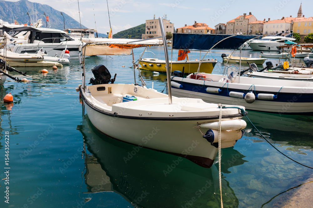 Small motorboats docked in calm marina water. Seaside lifestyle, coastal transportation, and nautical summer atmosphere Small motorboats docked in calm marina water. Seaside lifestyle, coastal transportation, and nautical summer atmosphere
