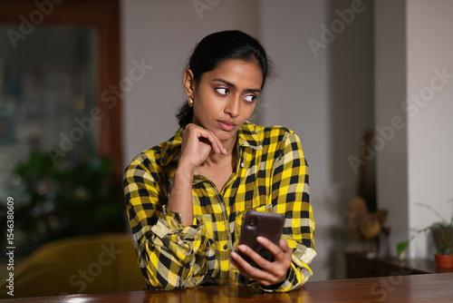 Unimpressed Woman Checking Her Phone Indoors