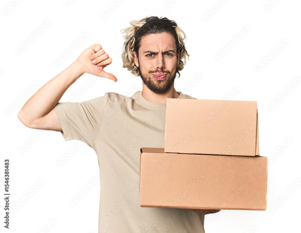 Young man with cardboard boxes in studio feels proud and self confident, example to follow. Young man with cardboard boxes in studio feels proud and self confident, example to follow.