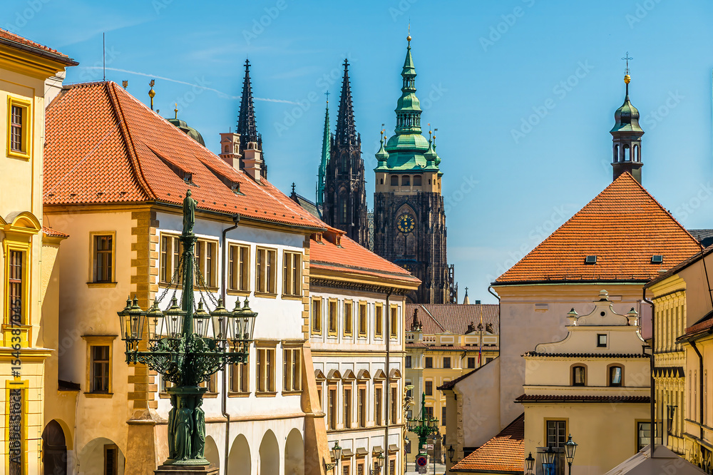 Obraz premium A view past buildings towards the center of the castle complex in Prague in springtime
