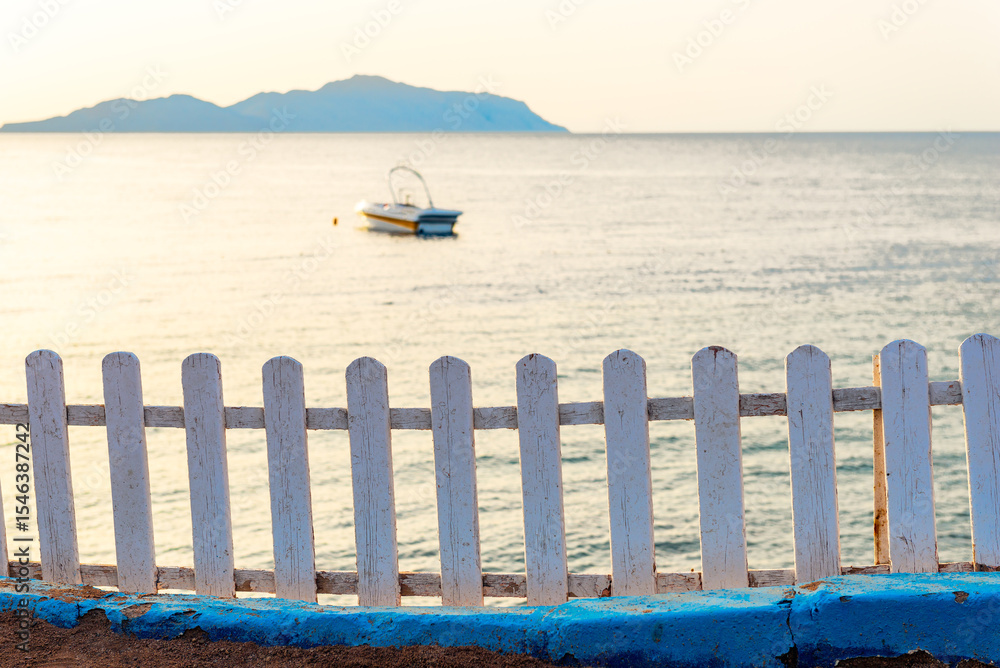 Fototapeta premium Seascape of Tiran Island in Red Sea with white wooden decorative fence on the shore. Egypt