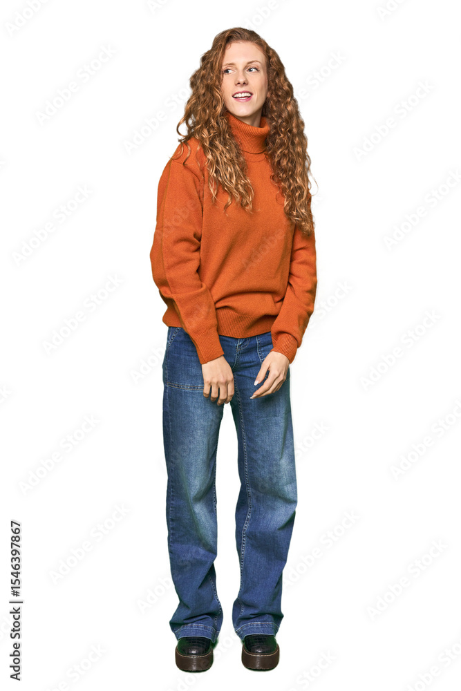 Full-body redhead portrait looks aside smiling, cheerful and pleasant. Full-body redhead portrait looks aside smiling, cheerful and pleasant.
