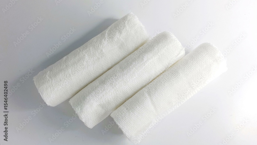 Fototapeta premium Three rolled gauze bandages on white background. Perfect for medical, healthcare, first aid, or hygiene websites and designs.