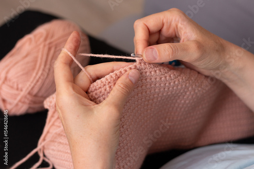 Woman crocheting. Hands closeup. Creativity, craft and hobby. Home photo
