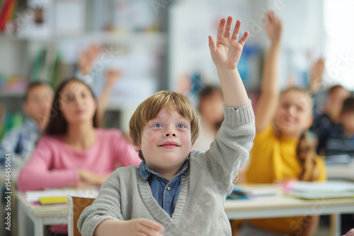 incusive classroom with a kid with special needs in the center raising the hand