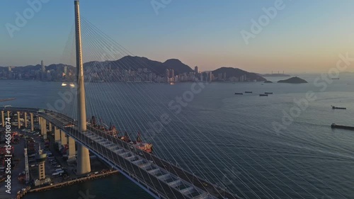 Aerial view of Stonecutters Bridge crossing the bay and container port at sunset in Hong Kong, 4k