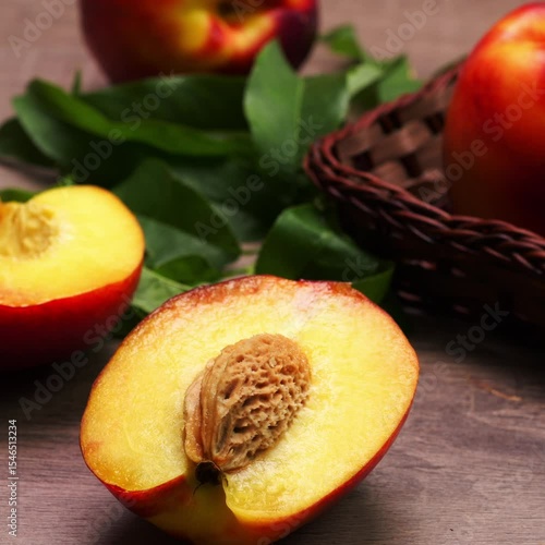 Wallpaper Mural Primo piano di mezza pesca con osso, pesche con foglie in secondo piano, video quadrato Torontodigital.ca