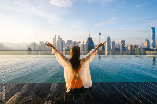 Canvas Print A woman in a bikini enjoys the rooftop pool and skyscrapers in a modern city
