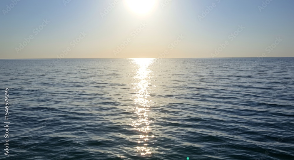 Fototapeta premium Serene ocean view reflecting sunlight under a clear blue sky creates tranquility
