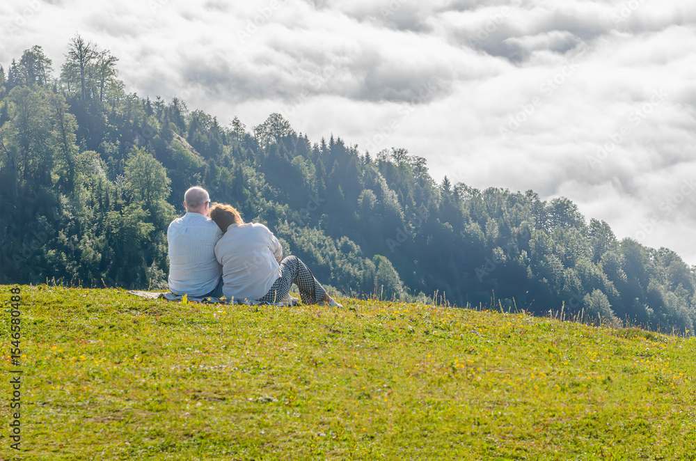 Naklejka premium Elderly couple enjoying a peaceful mountain view
