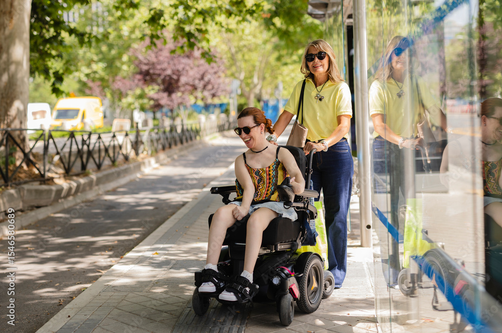 Volunteer pushing happy disabled woman in wheelchair at bus stop Volunteer pushing happy disabled woman in wheelchair at bus stop