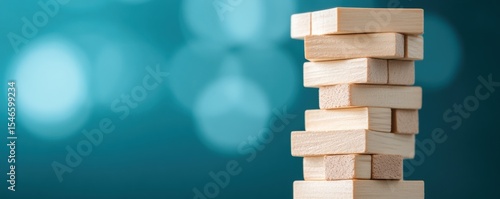 A close-up image of a wooden block tower game against a blue blurred background.