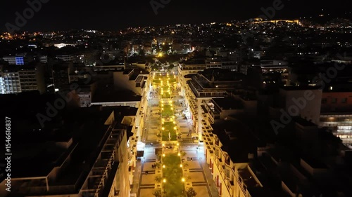 Aerial night view of Thessaloniki, Greece, captured by drone. Illuminated landmarks, city lights, and waterfront in cinematic 4K quality.