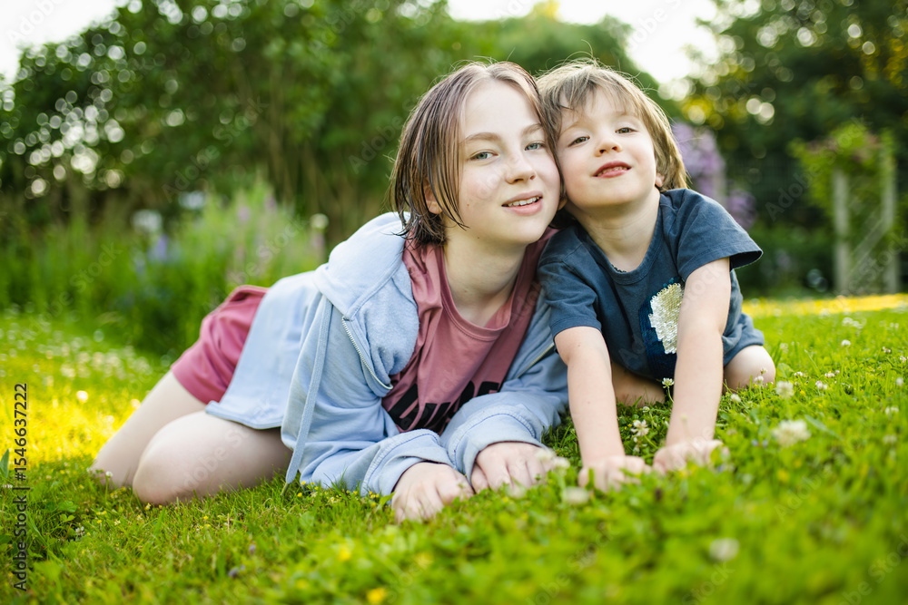 Cute big sister cuddling with her toddler brother. Adorable teenager girl hugging her small sibling. Children exploring nature. Cute big sister cuddling with her toddler brother. Adorable teenager girl hugging her small sibling. Children exploring nature.