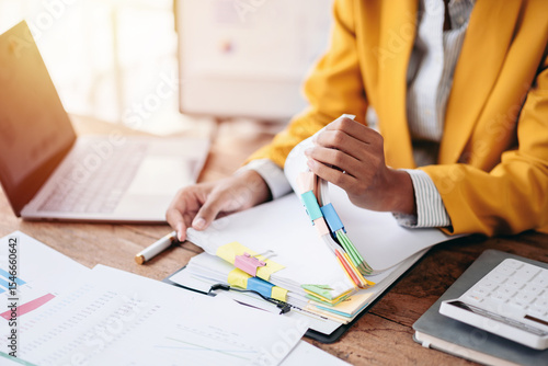 Business Woman Analyzing Financial Data Reports with Laptop Calculator and Hands Sorting Documents for Accounting Tax and Investment Planning at Office