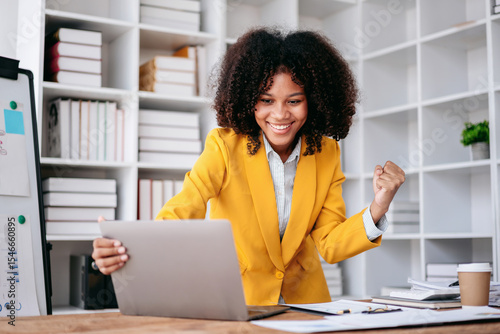 Businesswoman Celebrating Success at Office Desk With Laptop Computer Happy Young Professional Achievement For Online Business