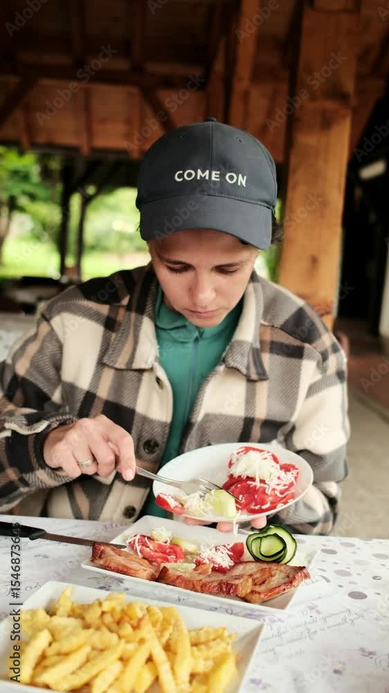 Woman preparing a plate with fresh tomato salad and cucumbers at a traditional Serbian meal outdoors. Sopska salata - Shopski salad. Vertical 4k footage Woman preparing a plate with fresh tomato salad and cucumbers at a traditional Serbian meal outdoors. Sopska salata - Shopski salad. Vertical 4k footage