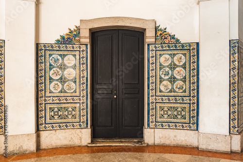 Elegant black door framed by colorful Portuguese azulejo tiles in Lisbon, perfect for travel, architecture, and design inspiration or cultural heritage projects.