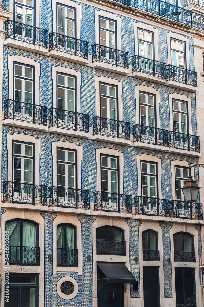 Fototapeta premium Elegant Lisbon architecture featuring blue azulejo tiles, classic iron balconies, and tall windows. Perfect for travel, culture, and European cityscape design inspiration.