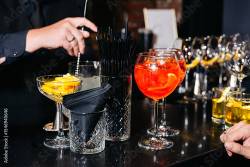 Bartender preparing cocktails at event bar station.