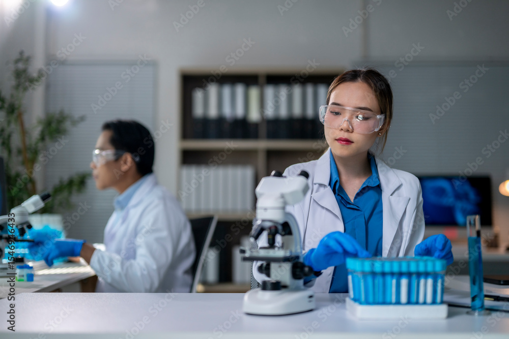 Scientists working with microscope and test tubes in laboratory Scientists working with microscope and test tubes in laboratory