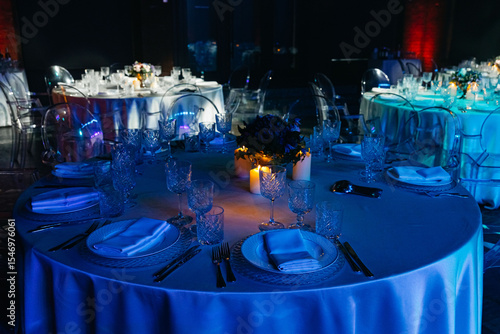 Elegant candlelit dinner tables at evening event.