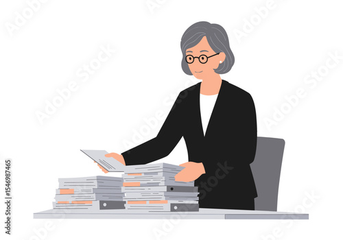 A lady with glasses in a black suit looks at papers on a desk with piles of papers