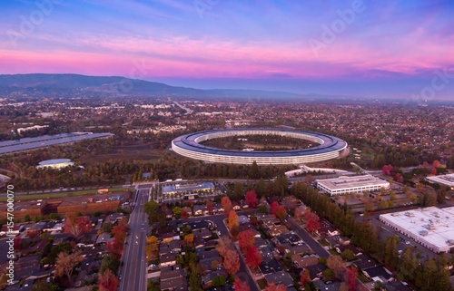 Aerial view of Apple Park headquarters in Santa Clara, California, USA, at sunset. The circular building houses Apple employees and promotes innovation.
