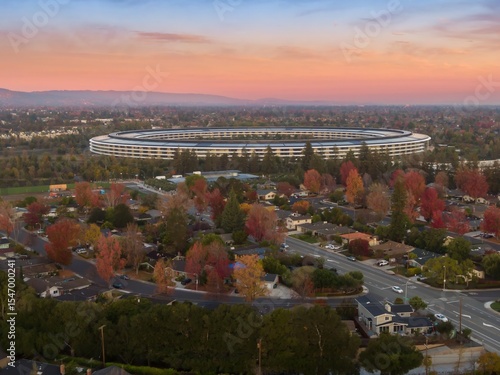 Apple Park, Apple's corporate headquarters, stands out in Santa Clara, California, USA. The circular building is surrounded by colorful autumn trees.