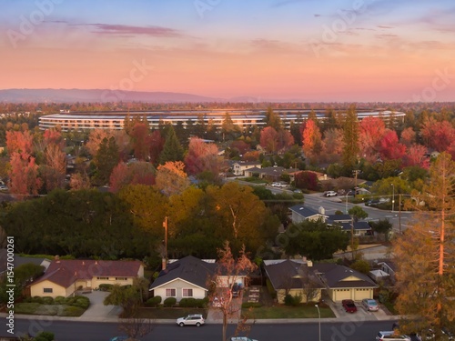 Apple Park, Apple's corporate headquarters, stands out in Santa Clara, California, USA. The circular building is surrounded by colorful autumn trees.