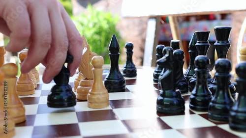 Casual outdoor chess match. Two person making moves on chess board. Fast strategic game for brain and intelligence.