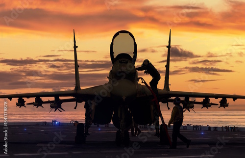 Fighter jet front view silhouette on aircraft carrier at sunset